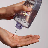 hand holding Kérastase Blond Absolu repairing serum with pure hyaluronic acid Canada